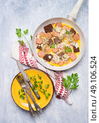 Homemade omelette in a frypan and plate with fork and knife on rustic wooden background, top view. Стоковое фото, агентство Ingram Publishing / Фотобанк Лори
