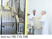 Man and woman holding plastic barrel next to machine. Стоковое фото, агентство Ingram Publishing / Фотобанк Лори