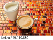 Coffee glass cup with cream on tiles red brown golden table. Стоковое фото, агентство Ingram Publishing / Фотобанк Лори
