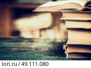 Stack of books on aged table, close up, place for text, retro styled. Стоковое фото, агентство Ingram Publishing / Фотобанк Лори