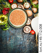 Fresh vegetables and ingredients with red lentil for healthy cooking on rustic background, top view, vertical border. Vegetarian food or diet eating concept. Стоковое фото, агентство Ingram Publishing / Фотобанк Лори