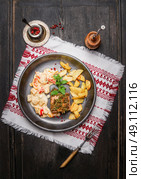Pork loin steaks with herbs crust, roast potatoes and salsa sauce in rustic plate , top view. Стоковое фото, агентство Ingram Publishing / Фотобанк Лори
