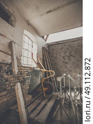 Wheelbarrow in a warn barn with sunlight coming through a window. Стоковое фото, агентство Ingram Publishing / Фотобанк Лори