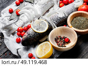 Seasoning for raw fish. Carcass raw fish on the kitchen table with spices. Стоковое фото, агентство Ingram Publishing / Фотобанк Лори