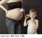 Little man talking to the unborn sibling. Стоковое фото, агентство Ingram Publishing / Фотобанк Лори