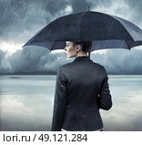 Businesswoman standing with an black umbrella. Стоковое фото, агентство Ingram Publishing / Фотобанк Лори