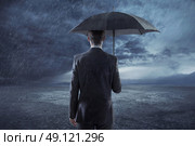 Depressed businessman standing with an umbrella. Стоковое фото, агентство Ingram Publishing / Фотобанк Лори