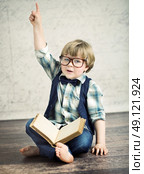 Clever boy reading an interesting novel. Стоковое фото, агентство Ingram Publishing / Фотобанк Лори