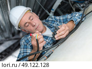 electrician wiring inside ceiling competent. Стоковое фото, агентство Ingram Publishing / Фотобанк Лори