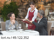 hospitable waitress taking couples order in gastronomy restaurant. Стоковое фото, агентство Ingram Publishing / Фотобанк Лори