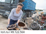 woman mechanic picking axle in car scrap yard. Стоковое фото, агентство Ingram Publishing / Фотобанк Лори