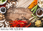 Asian food background with vegetarian cooking ingredients and chopsticks : tofu, noodles, ginger, lemongrass, cut vegetables, Sprout,green onion ,hoisin and austern sauce,  top view, frame. Стоковое фото, агентство Ingram Publishing / Фотобанк Лори