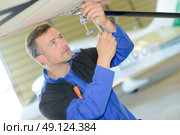 Man working on the underside of an aircraft. Стоковое фото, агентство Ingram Publishing / Фотобанк Лори