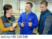 ironworks teacher showing students how to securely use gas welder. Стоковое фото, агентство Ingram Publishing / Фотобанк Лори