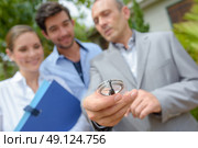 Couple with estate agent holding compass. Стоковое фото, агентство Ingram Publishing / Фотобанк Лори