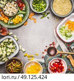 Healthy vegetarian dish preparation with Diced feta cheese, cut vegetables in bowls, pearl barley , cooking spoon and kitchen knife, top view. Clean Diet nutrition concept. Стоковое фото, агентство Ingram Publishing / Фотобанк Лори