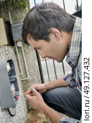 Electrician repairing an intercom system. Стоковое фото, агентство Ingram Publishing / Фотобанк Лори
