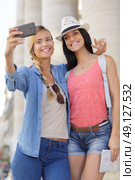 cheerful tourist female friends taking photos of themselves. Стоковое фото, агентство Ingram Publishing / Фотобанк Лори