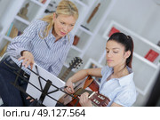 teenage girl learning to play the guitar. Стоковое фото, агентство Ingram Publishing / Фотобанк Лори