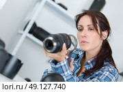 photographer checking a lens with a magnifying glass. Стоковое фото, агентство Ingram Publishing / Фотобанк Лори