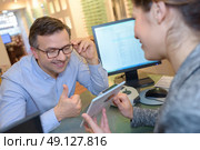 beautiful optician helping male customer choosing eye glasses. Стоковое фото, агентство Ingram Publishing / Фотобанк Лори