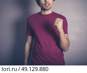 A young man in purple is winning and displaying an awesome fist pump. Стоковое фото, агентство Ingram Publishing / Фотобанк Лори