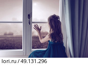 Miserable child looking through window. Стоковое фото, агентство Ingram Publishing / Фотобанк Лори