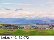 Spring fields and orchard blossom on foothills. Sunny green spring landscape. Spring fields and blooming trees. Village and town behind foothills. Стоковое фото, агентство Ingram Publishing / Фотобанк Лори