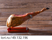 Iberian ham pata negra from Spain on wood background. Стоковое фото, агентство Ingram Publishing / Фотобанк Лори