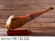 Iberian ham pata negra from Spain on wood background. Стоковое фото, агентство Ingram Publishing / Фотобанк Лори