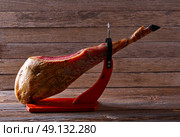 Iberian ham pata negra from Spain on wood background. Стоковое фото, агентство Ingram Publishing / Фотобанк Лори