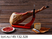 Iberian ham pata negra from Spain with manchego cheese on wood background. Стоковое фото, агентство Ingram Publishing / Фотобанк Лори