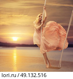 Slim lady standing on the wooden seesaw. Стоковое фото, агентство Ingram Publishing / Фотобанк Лори