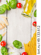 spaghetti cooking ingredients: oil,basil, tomatoes  and parmesan on white wooden background, frame, top view. Стоковое фото, агентство Ingram Publishing / Фотобанк Лори