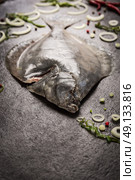 Raw flounder fish with spices on dark background. Стоковое фото, агентство Ingram Publishing / Фотобанк Лори