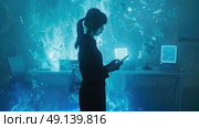 A woman stands in a high-tech office at night, engrossed in her smartphone, surrounded by holographic screens and digital projections. Стоковое AI-изображение, AI-художник Данила Большаков / Фотобанк Лори