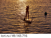 SUP Stand up Surf girl with paddle at sunset. Стоковое фото, агентство Ingram Publishing / Фотобанк Лори