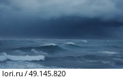 Powerful ocean storm with crashing waves and distant lightning — ideal for climate change, natural disasters, or dramatic weather visuals. Стоковое видео, видеограф Башкирова Анна / Фотобанк Лори