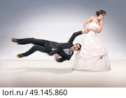 Portrait of a stubborn, young bride holding a groom. Стоковое фото, агентство Ingram Publishing / Фотобанк Лори