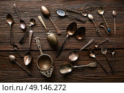 Vintage retro tea spoons and Strainers silver  on wooden background. Стоковое фото, агентство Ingram Publishing / Фотобанк Лори