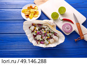Ceviche peruvian recipe with fried banana and ingredients on wooden blue table. Стоковое фото, агентство Ingram Publishing / Фотобанк Лори