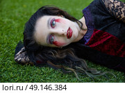 Halloween kid girl custome with bloody makeup on backyard turf. Стоковое фото, агентство Ingram Publishing / Фотобанк Лори