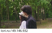 A young couple walks through a green summer park. Стоковое видео, видеограф Ярославский Максим / Фотобанк Лори