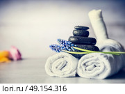 Spa massage setting with towels, hot stones and blue flowers, close up, wellness concept, front view. Стоковое фото, агентство Ingram Publishing / Фотобанк Лори