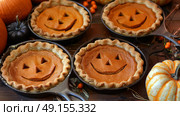 Delightfully Festive Halloween Pumpkin Pies Adorned with Charming JackoLantern Faces for Everyone. Стоковое AI-изображение, AI-художник Anastasy Yarmolovich / Фотобанк Лори