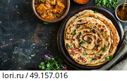 Homemade Kerala wheat paratha or layered parotta served with Paneer curry. Стоковое AI-изображение, AI-художник Anastasy Yarmolovich / Фотобанк Лори