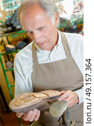 Cobbler holding shoe with no sole. Стоковое фото, агентство Ingram Publishing / Фотобанк Лори