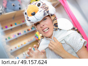 young woman looking for costume in rental store. Стоковое фото, агентство Ingram Publishing / Фотобанк Лори