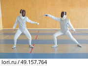 Two people in fencing joust. Стоковое фото, агентство Ingram Publishing / Фотобанк Лори