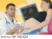 doctor doing an echography to pregnant woman. Стоковое фото, агентство Ingram Publishing / Фотобанк Лори